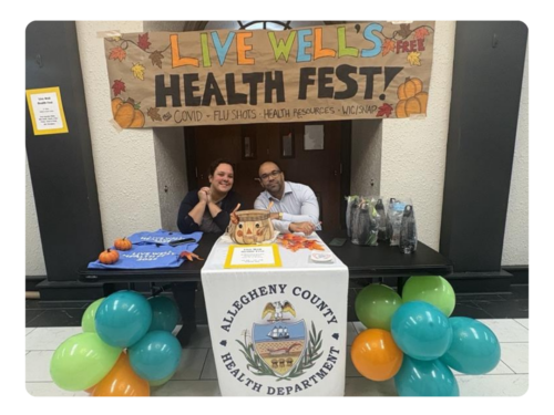 Two Live Well representatives sit at the check-in table for the Live Well Health Fest that happened in 2025.